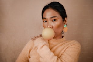 a woman blowing a bubble with her nose