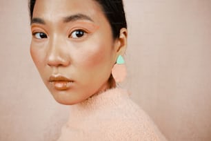 a close up of a person wearing a sweater and earrings