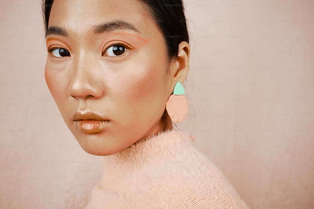 a close up of a person wearing a sweater and earrings