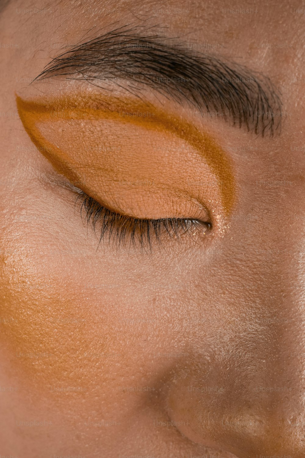 a close up of a woman's face with a yellow eye shadow