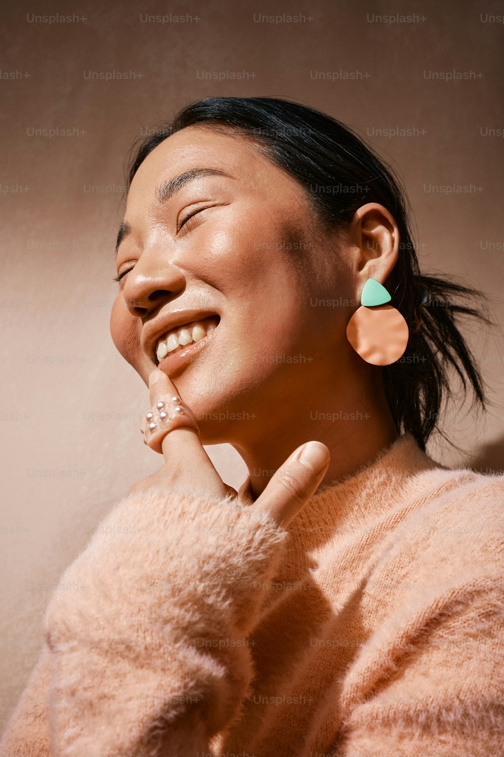 a woman smiling with a pair of earrings on her ear