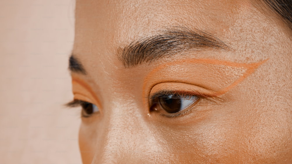 a close up of a woman's face with a brown eyeliner