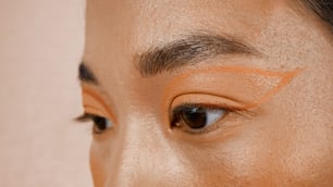 a close up of a woman's face with a brown eyeliner