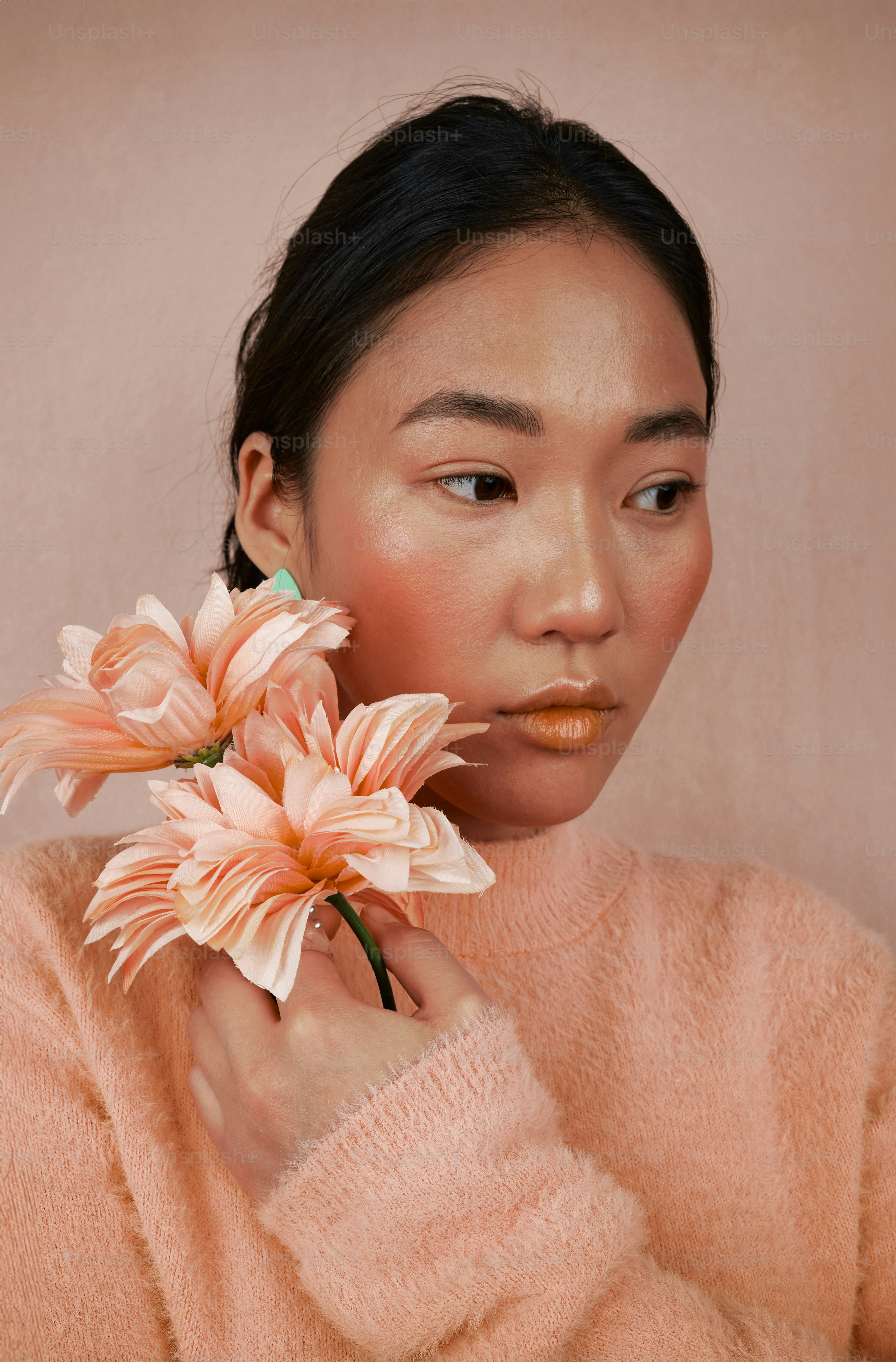 A woman with a flower in her hand photo – Peach fuzz Image on Unsplash
