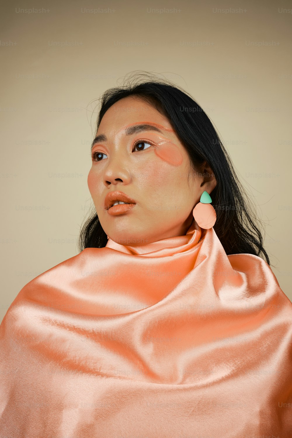 a woman wearing a pink shawl and earrings