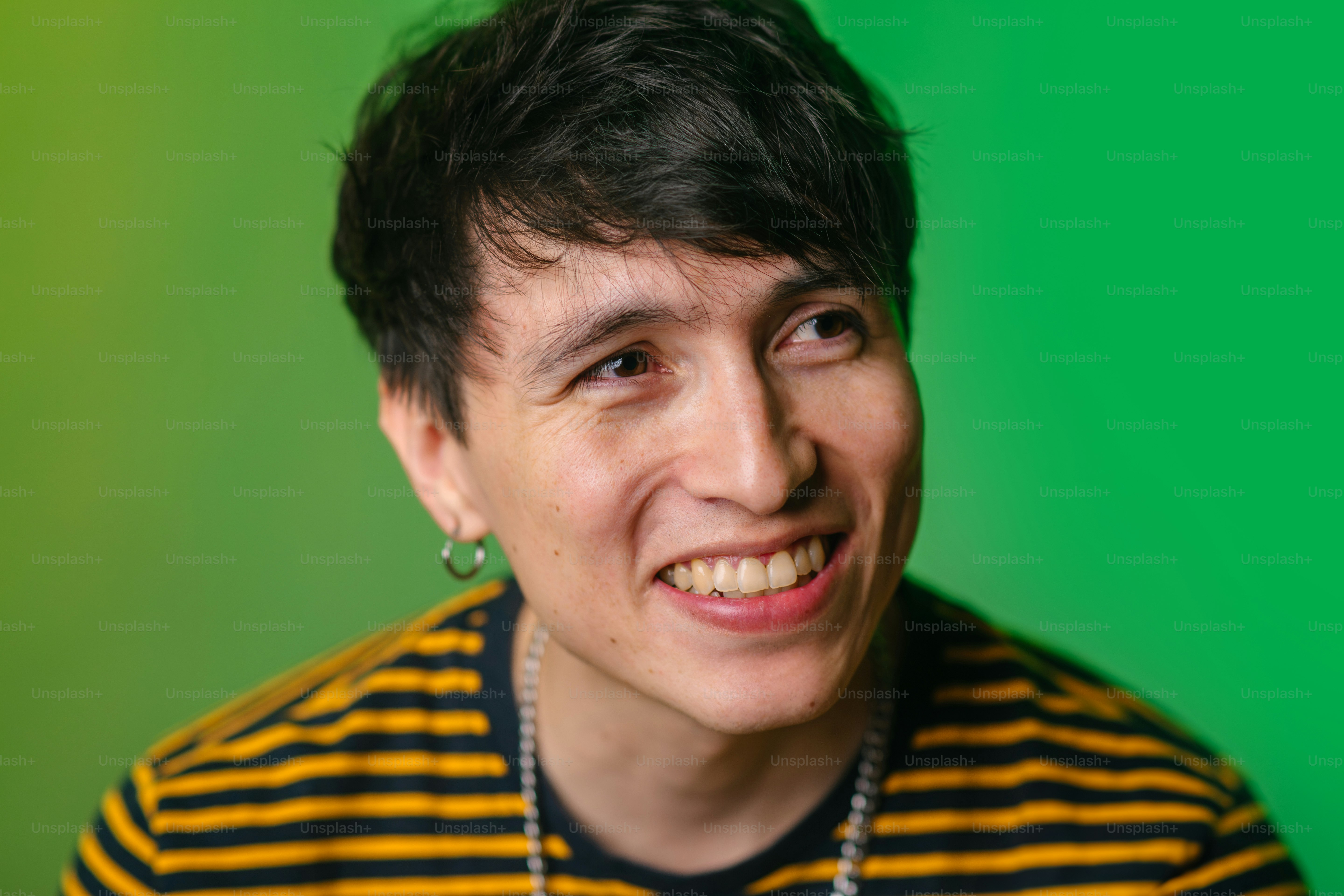 ネックレスと緑の背景を持つ人