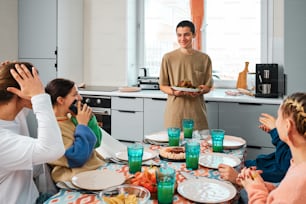 a group of people sitting around a table with plates of food