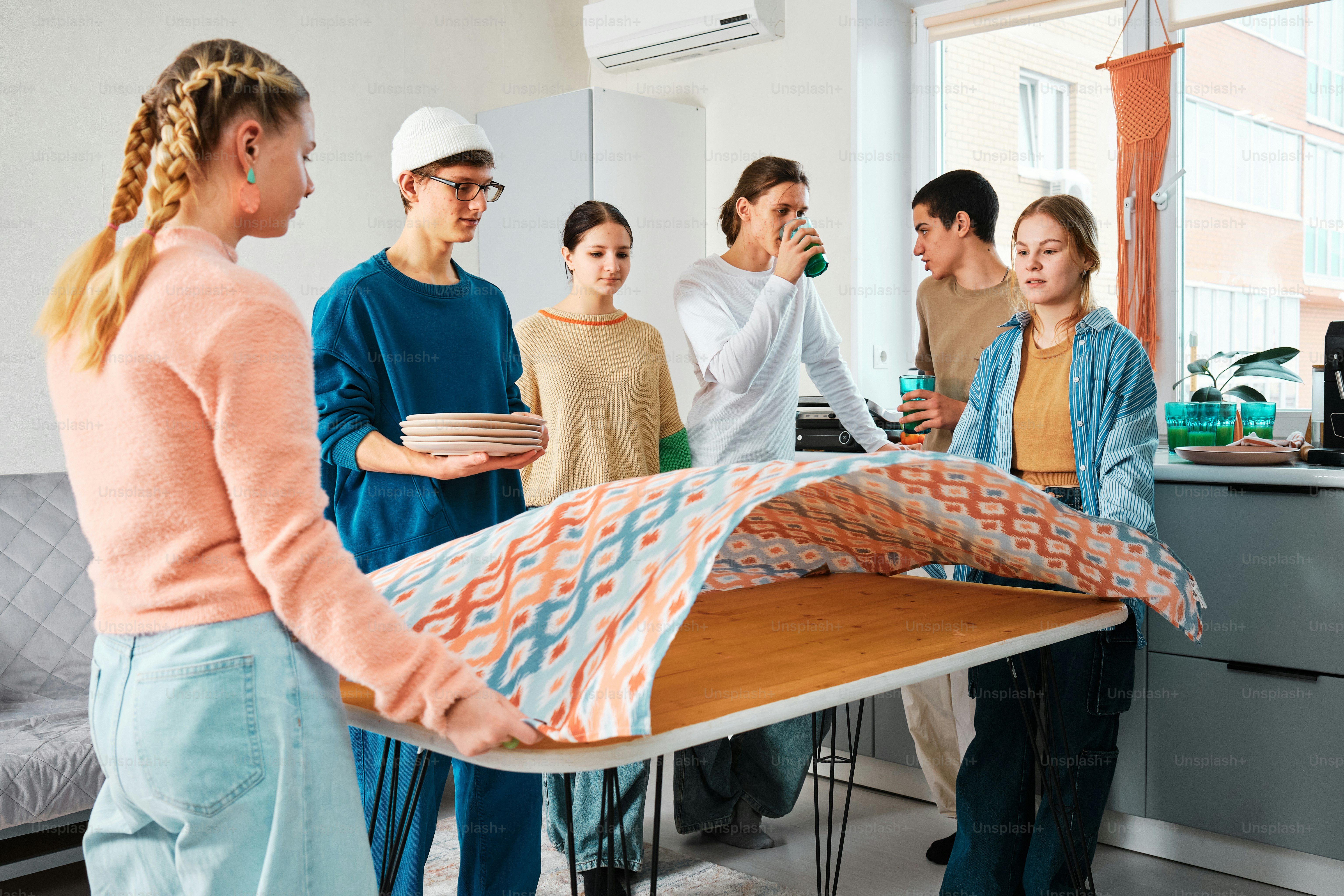 eine Gruppe von Menschen, die um einen Tisch herum stehen