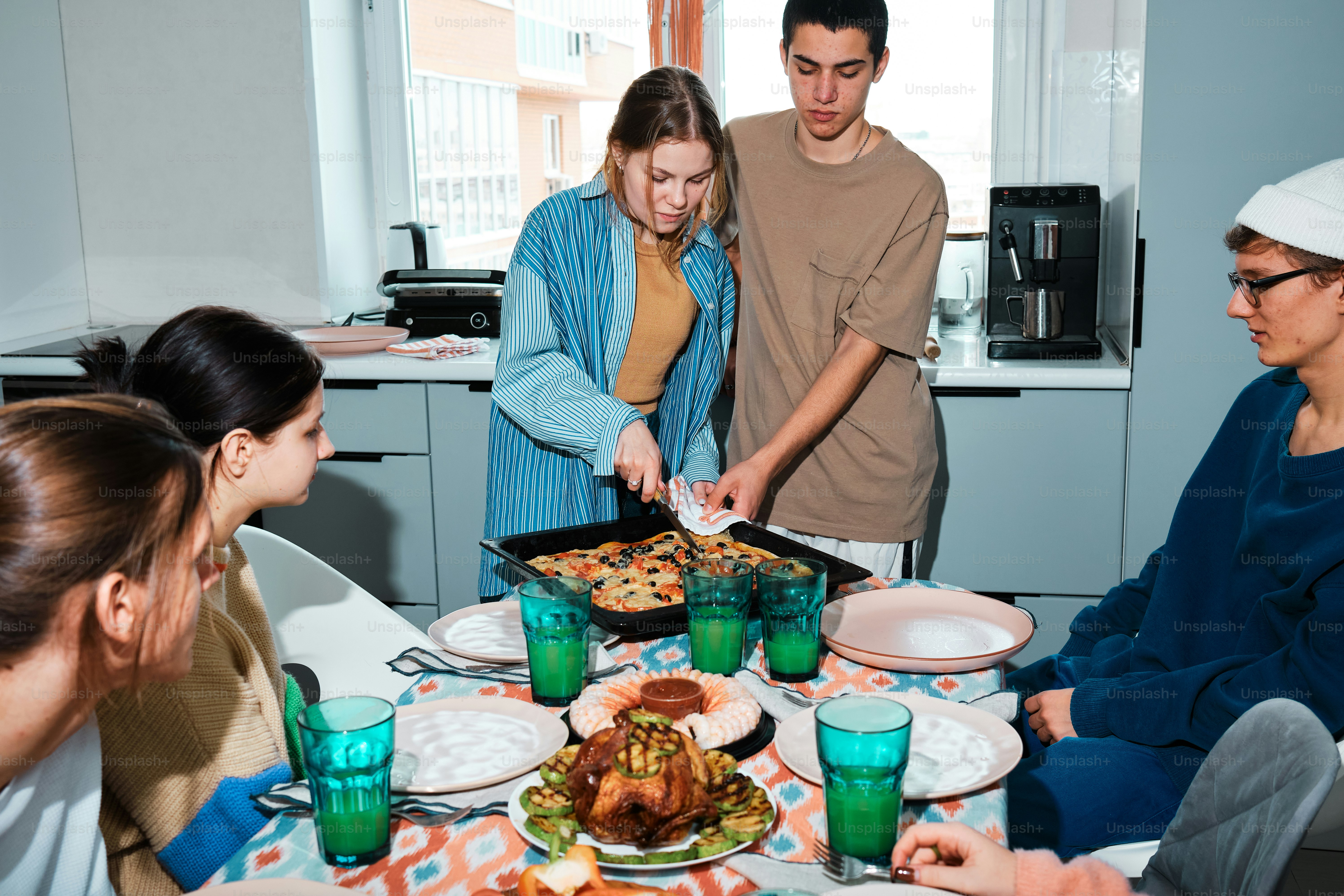 A group of people standing around a table with food photo – Friends ...