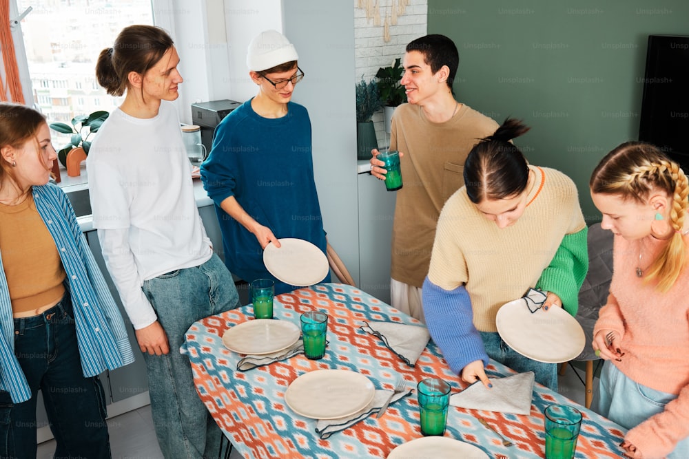 a group of people standing around a table with plates on it
