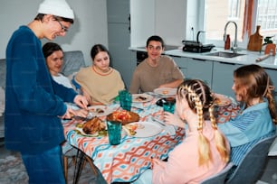 eine Gruppe von Menschen, die um einen Tisch sitzen und Essen essen