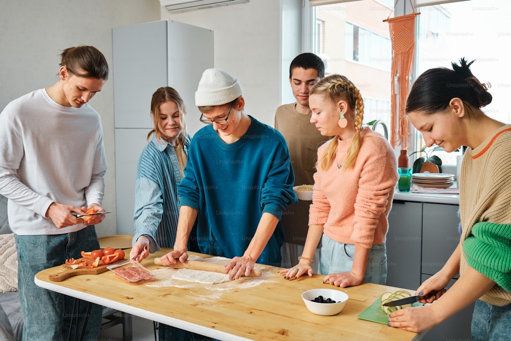 a group of people standing around a table preparing food