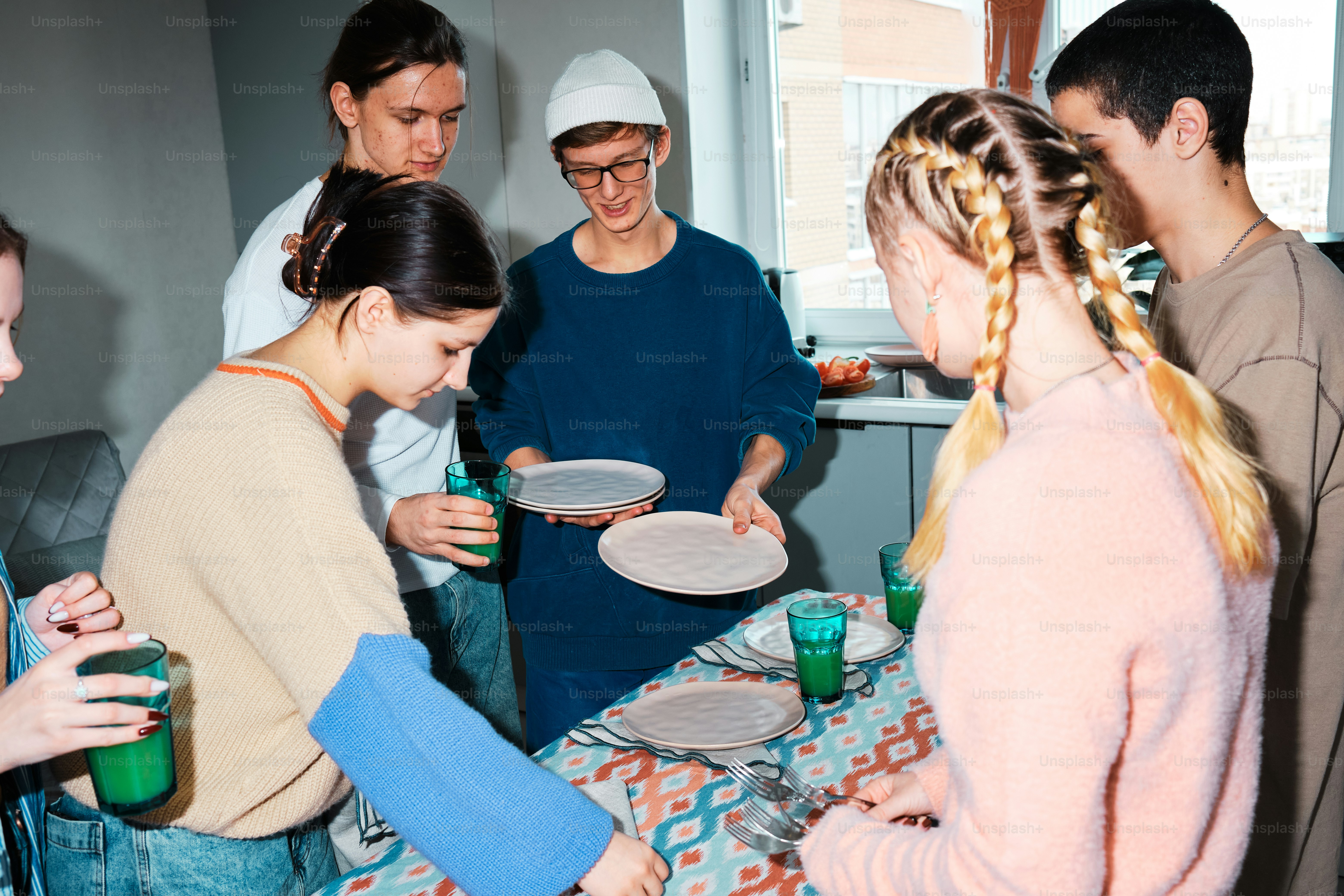 A group of people standing around a table photo – Friends Image on Unsplash
