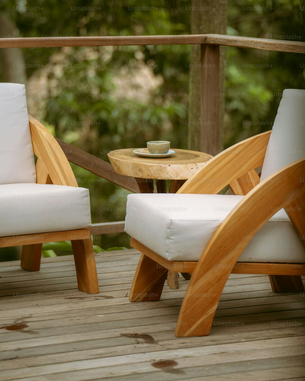 a couple of chairs sitting on top of a wooden deck