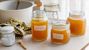 four jars of honey sit on a table