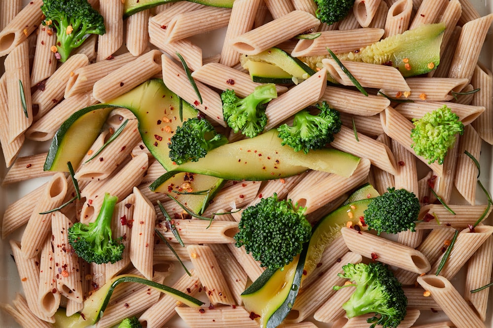 a plate of pasta with broccoli and other vegetables