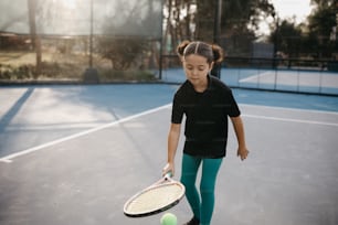 a young girl holding a tennis racquet on a tennis court