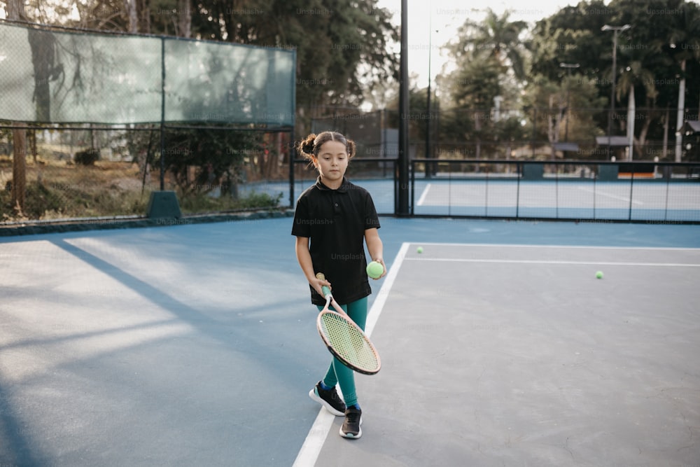 un niño sosteniendo una raqueta de tenis en una cancha de tenis