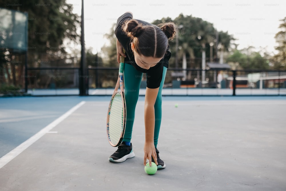 una mujer agachada con una raqueta de tenis