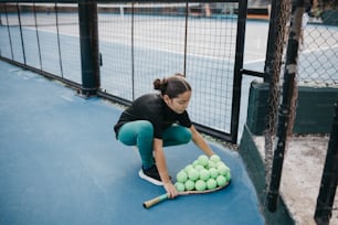 a woman kneeling on a tennis court holding a racket