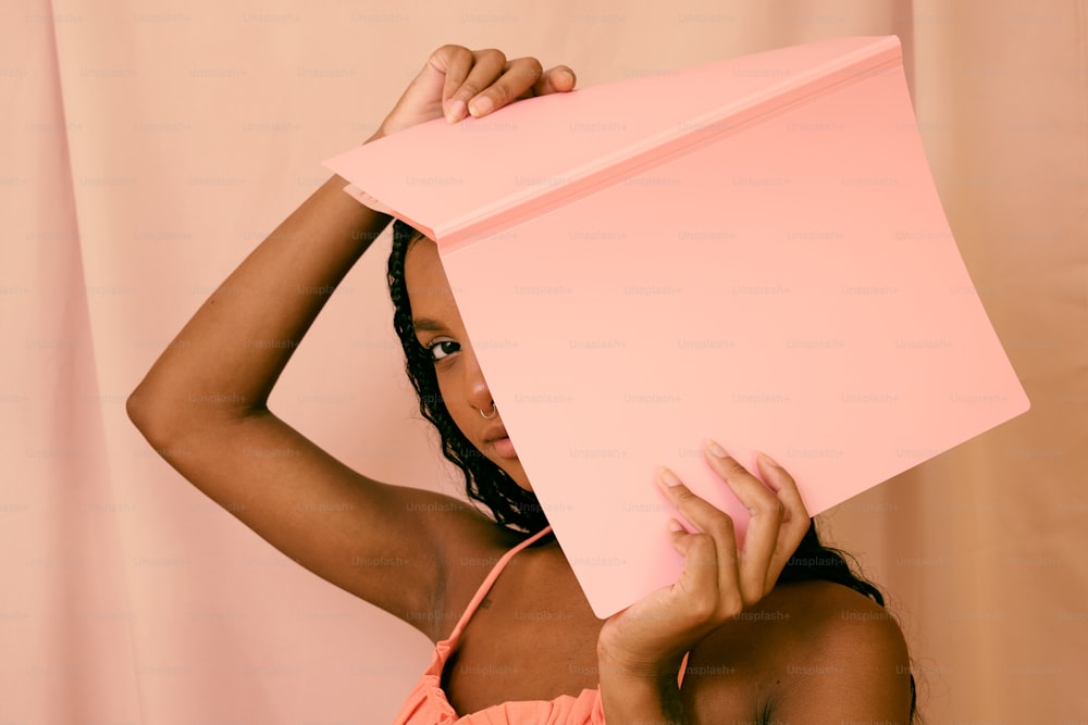 a woman holding a pink object over her head