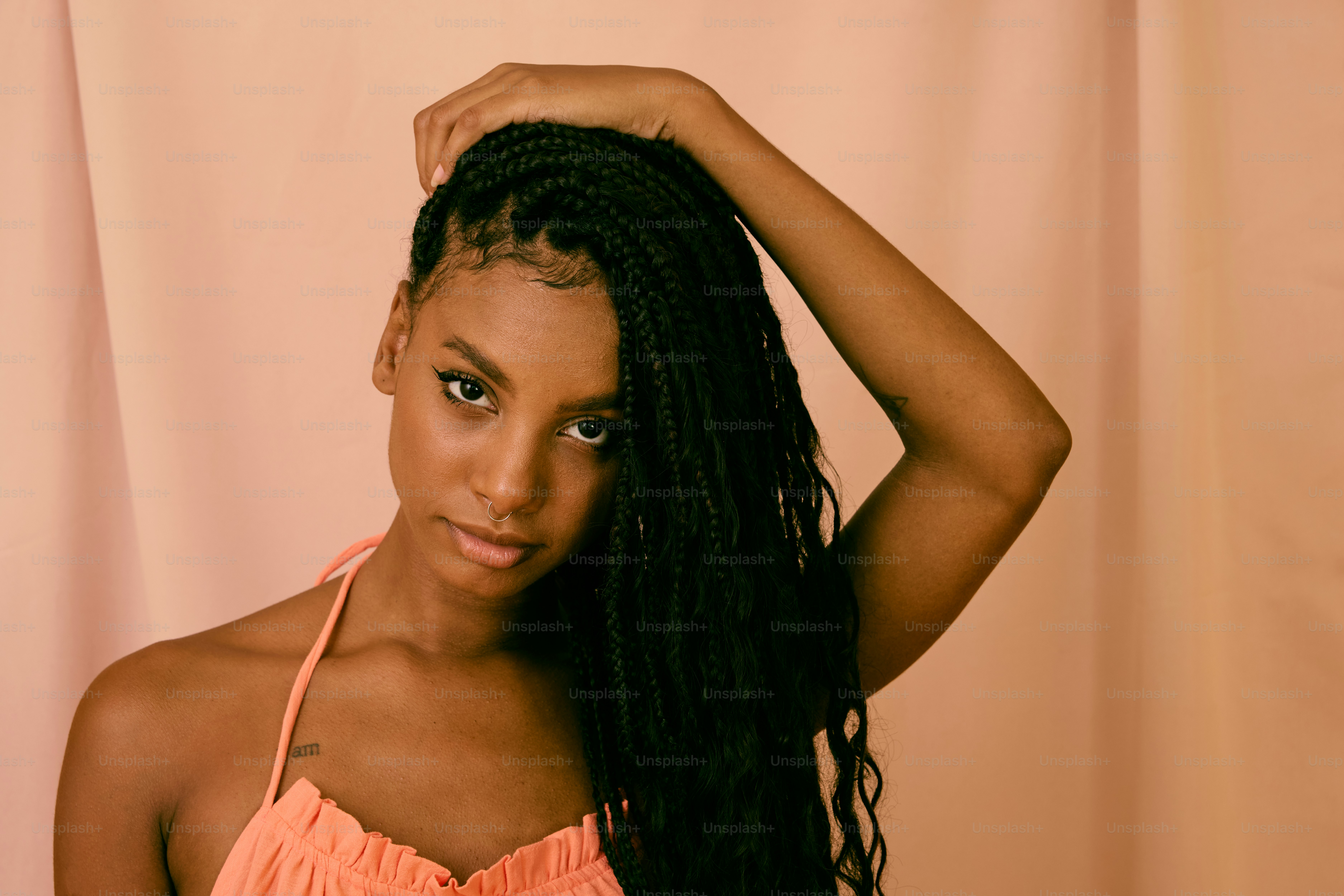 a woman with long hair wearing an orange top