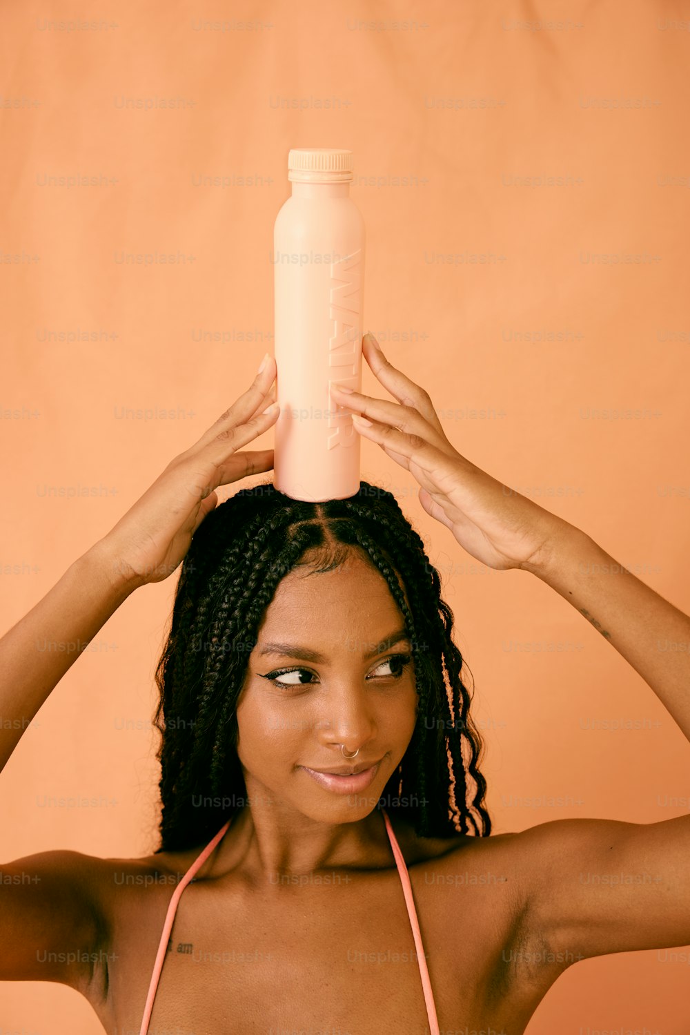 una mujer sosteniendo una botella sobre su cabeza