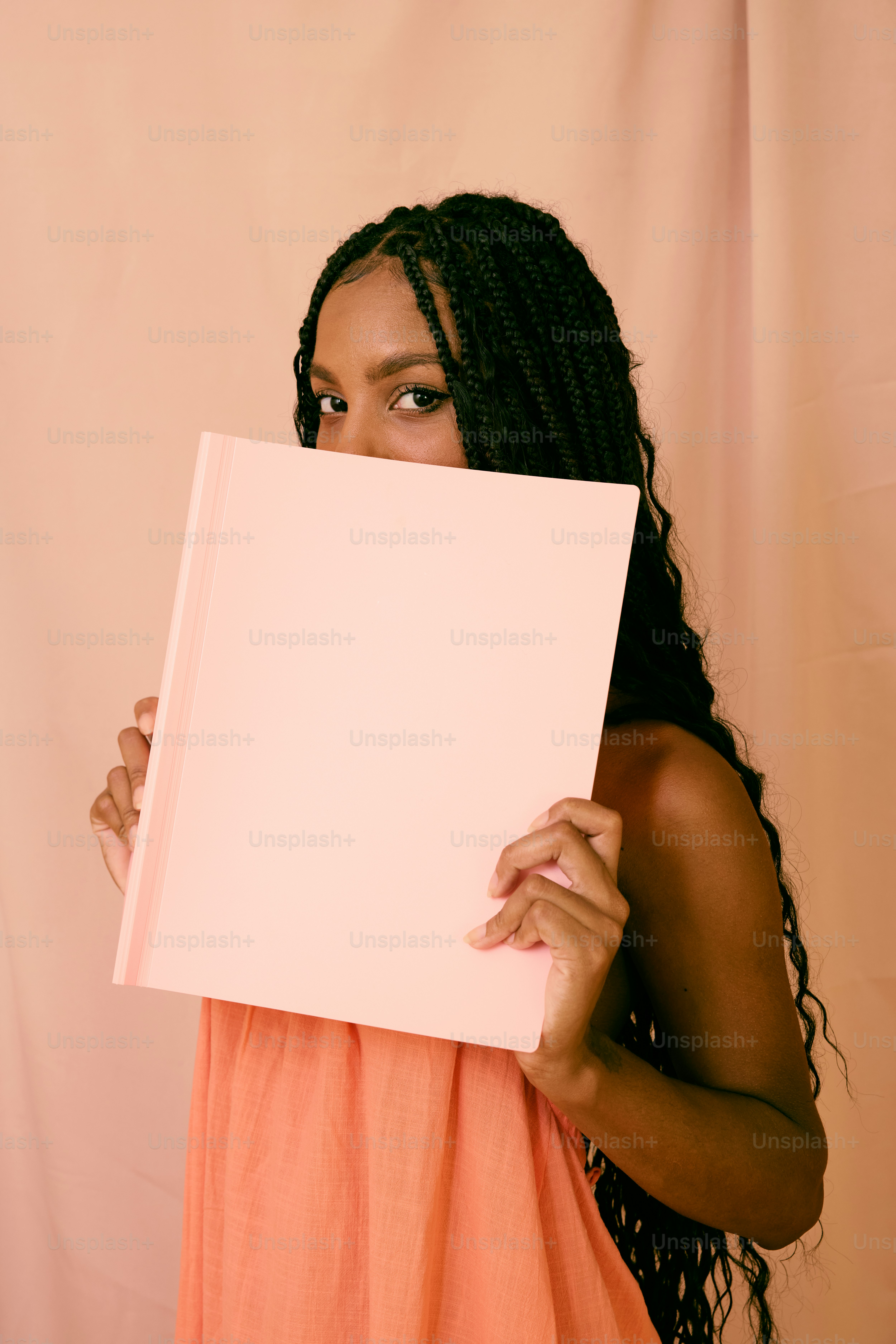 a woman in an orange dress holding a white sheet