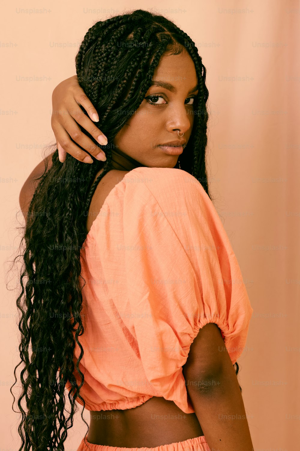 a woman with long hair wearing an orange top