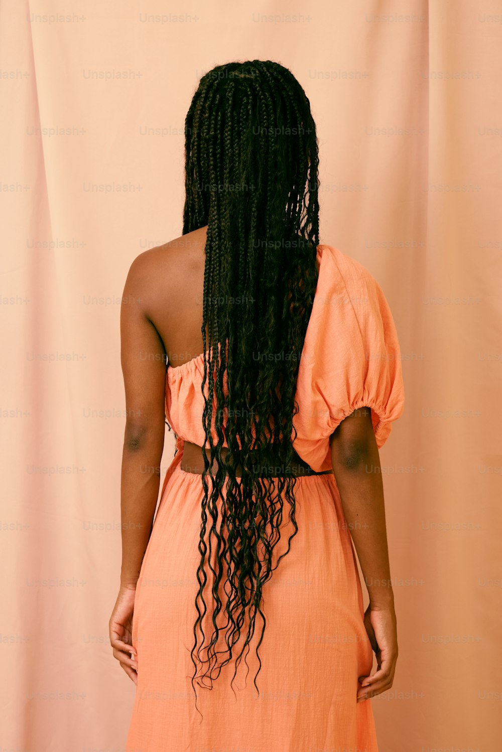 eine Frau in einem orangefarbenen Kleid mit langen Haaren