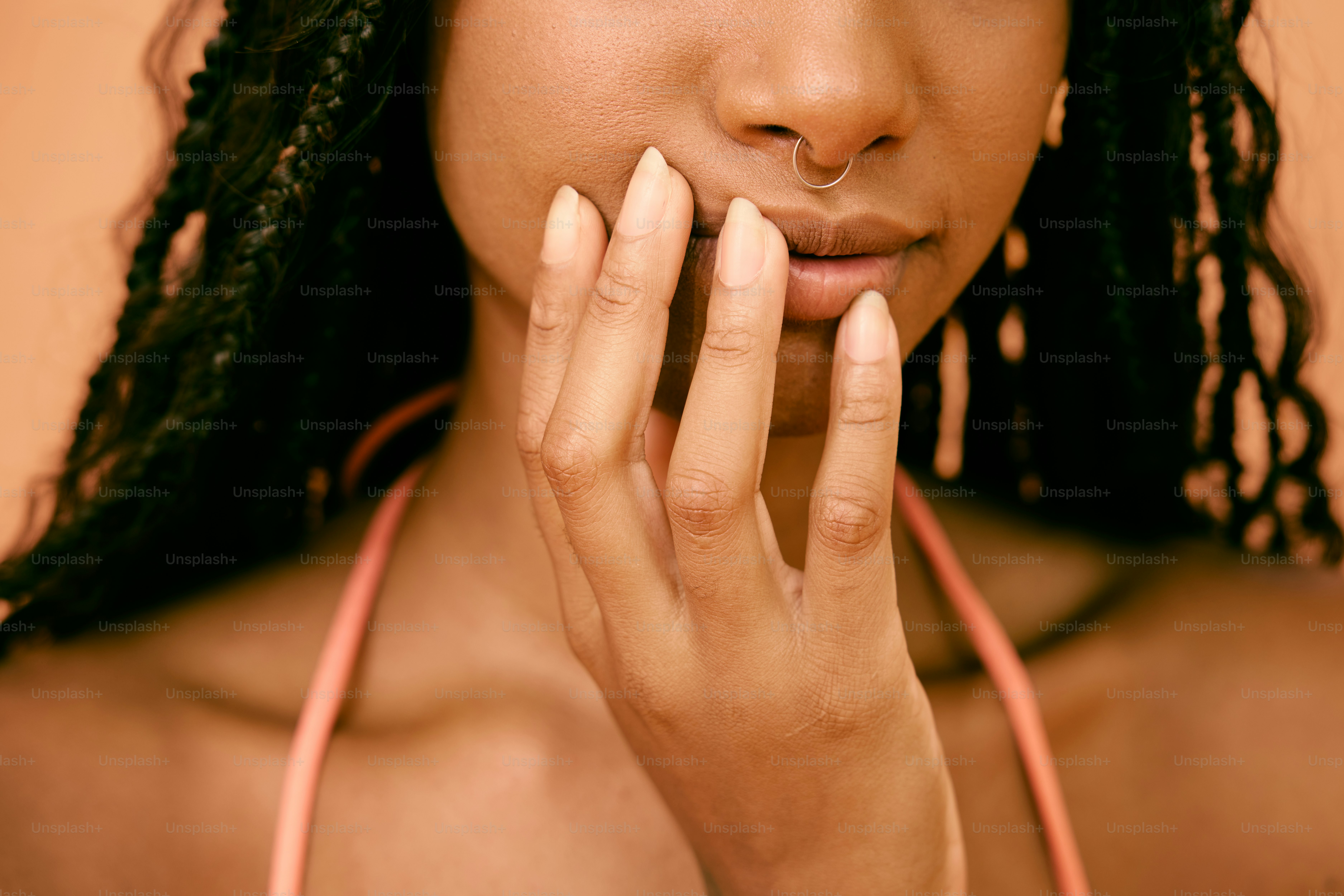 a close up of a woman holding her hand to her face