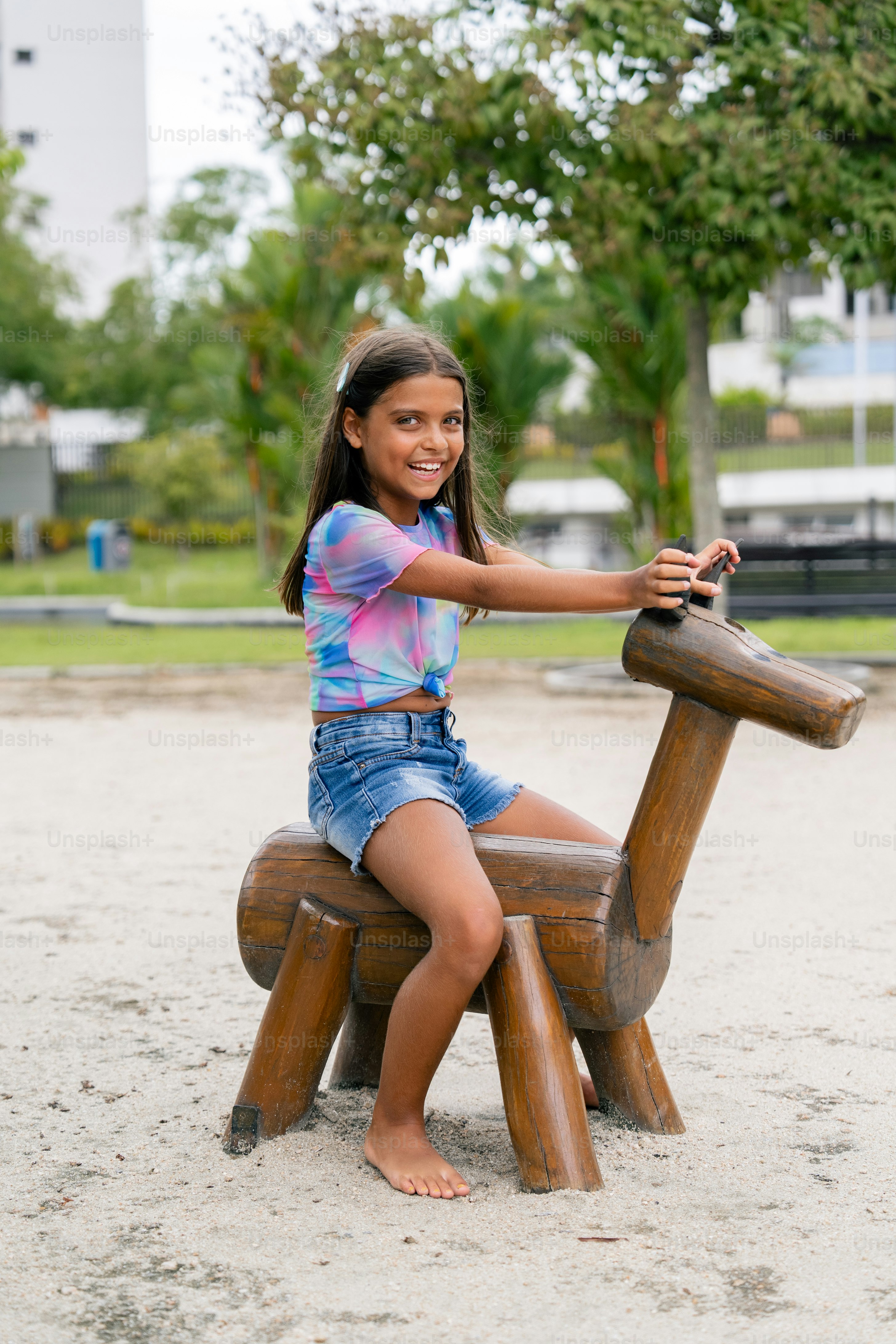 A young girl sitting on a wooden bench photo – Playground Image on Unsplash