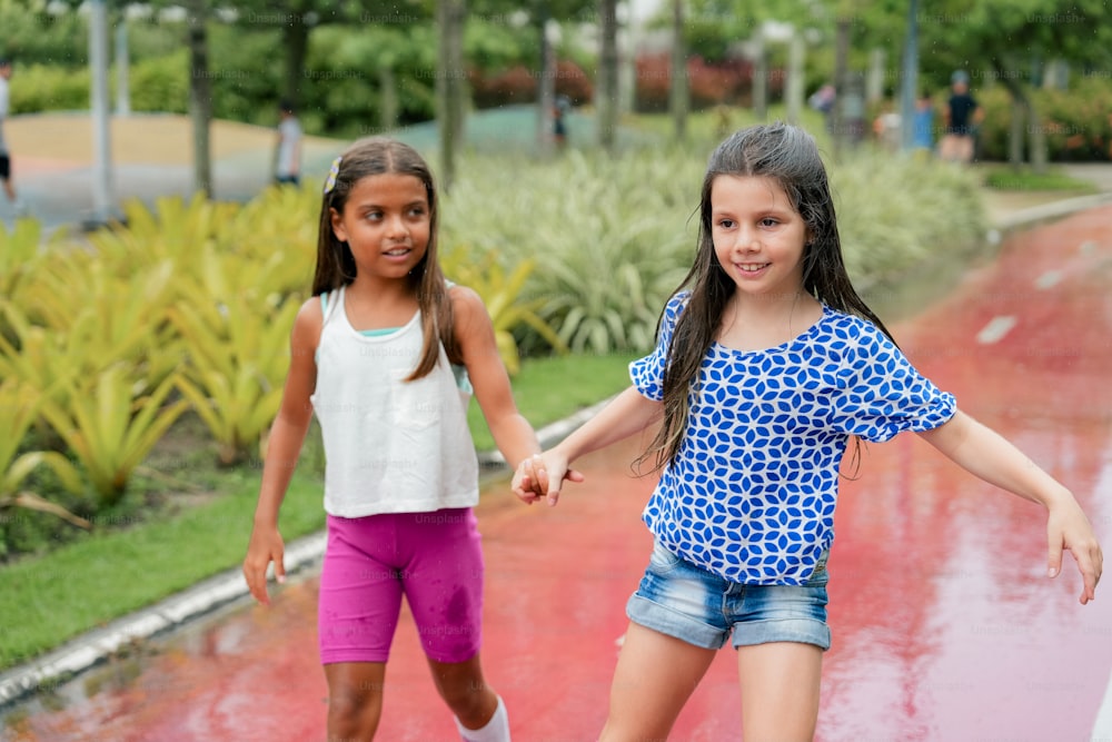 two young girls are playing in a puddle
