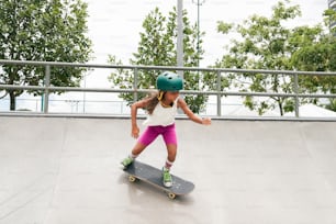 a young girl riding a skateboard down a ramp