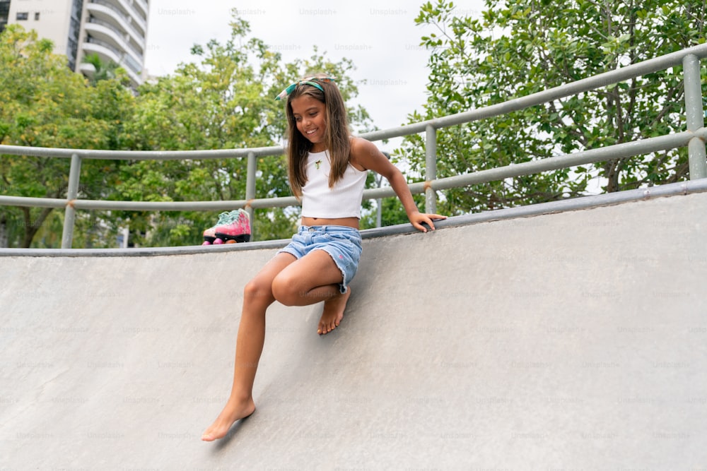 una giovane ragazza che cavalca uno skateboard sul lato di una rampa
