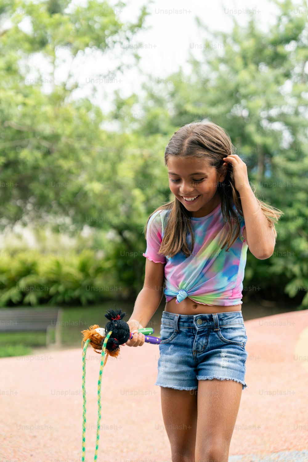 a girl in a tie dye shirt is holding a toy