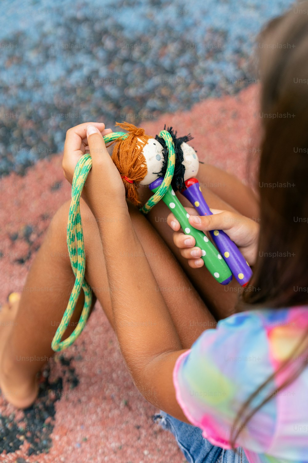 une petite fille assise sur le sol jouant avec des jouets