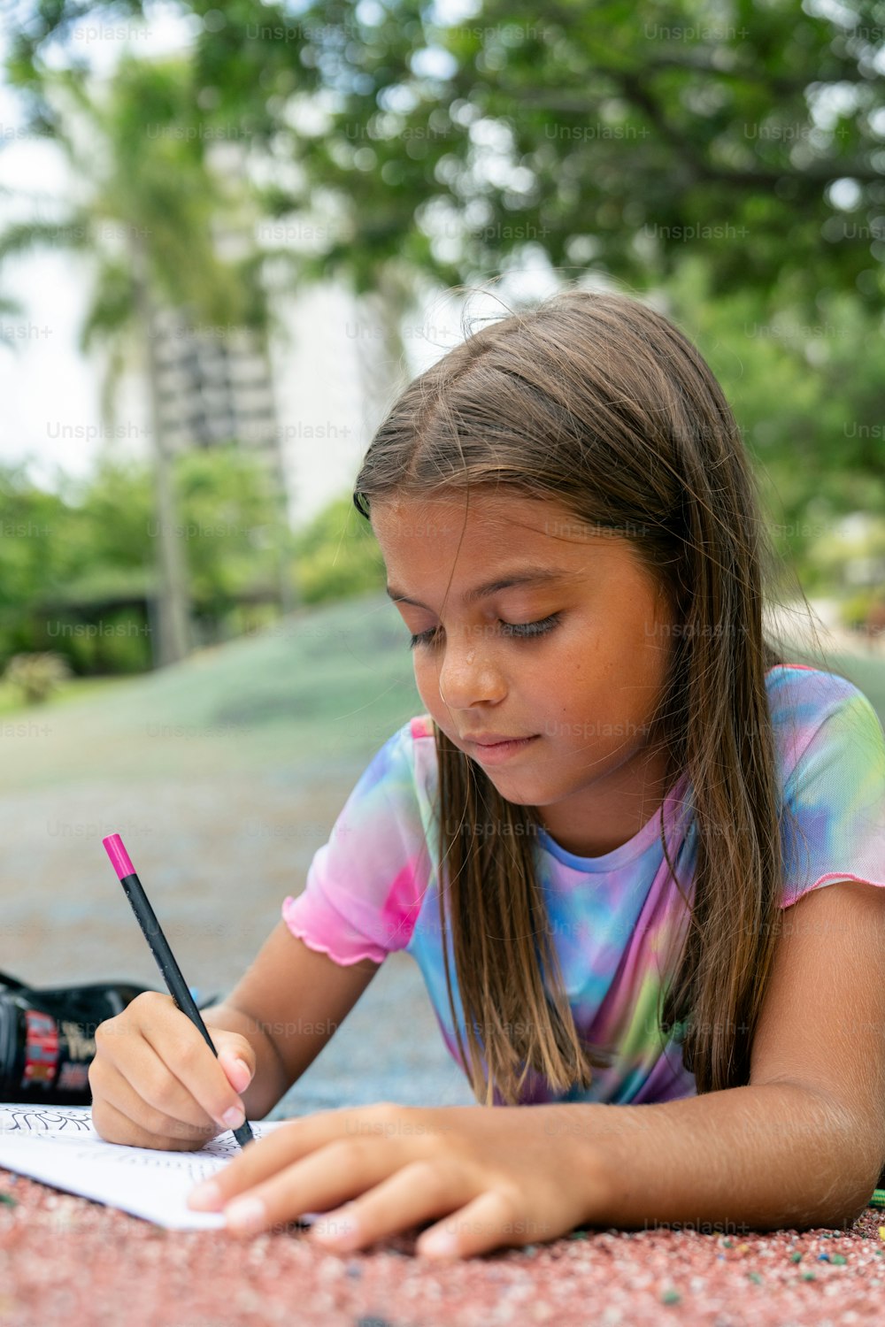 une petite fille écrivant sur un morceau de papier