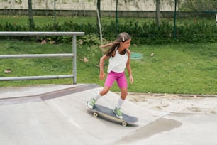 a young girl riding a skateboard on a ramp