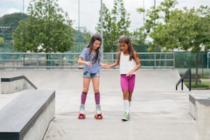 two young girls riding skateboards at a skate park