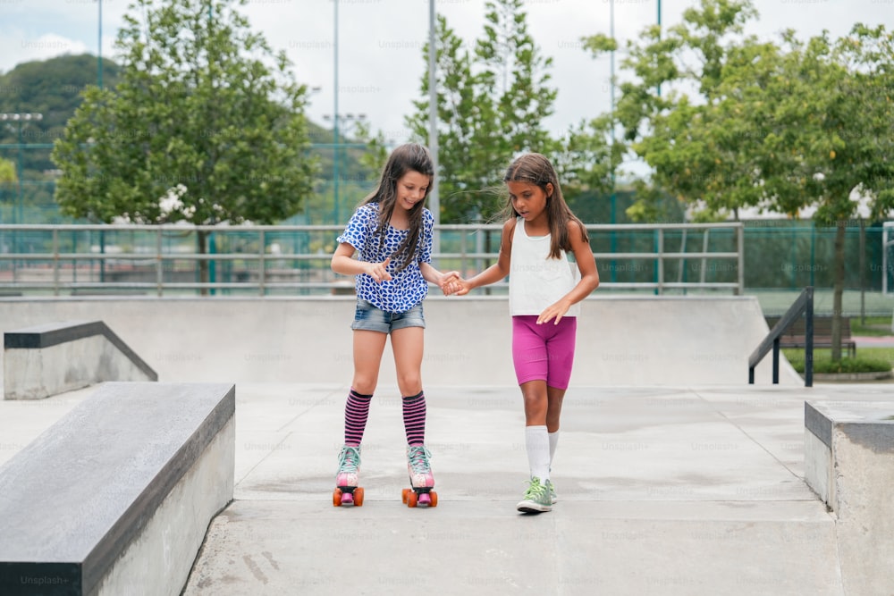 two young girls riding skateboards at a skate park