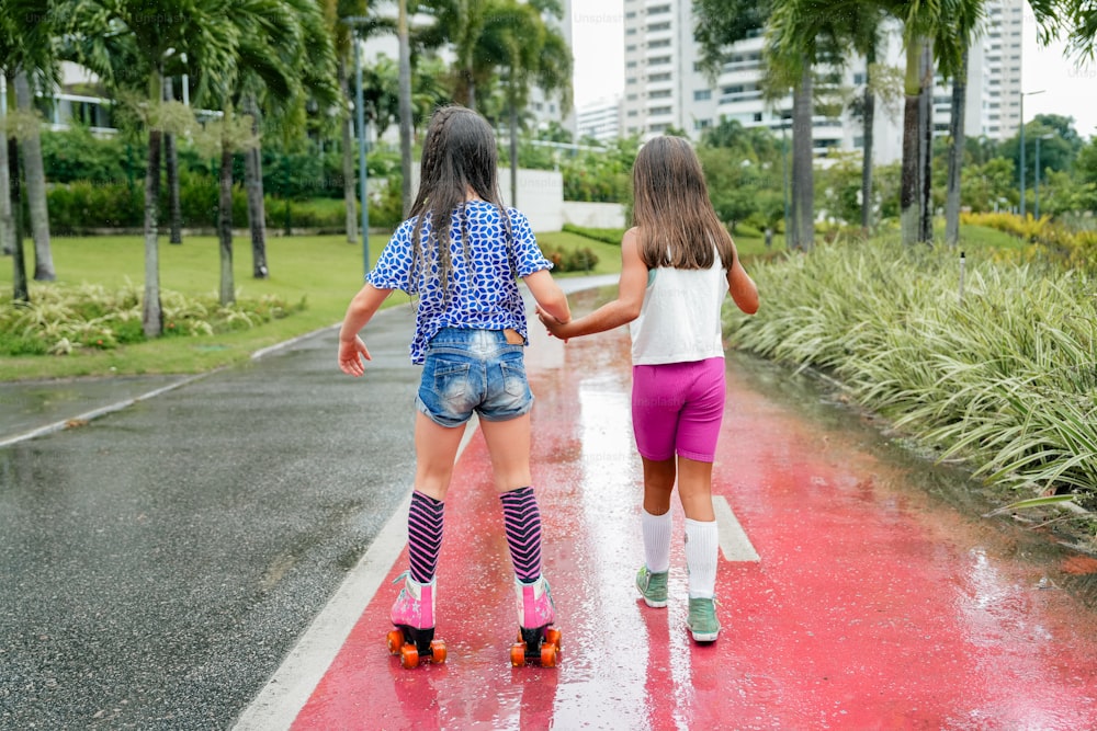 two little girls walking down the street in the rain