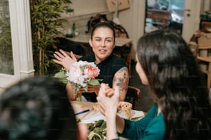a woman sitting at a table with a bouquet of flowers