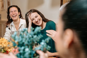 un groupe de personnes assises autour d’une table en train de rire
