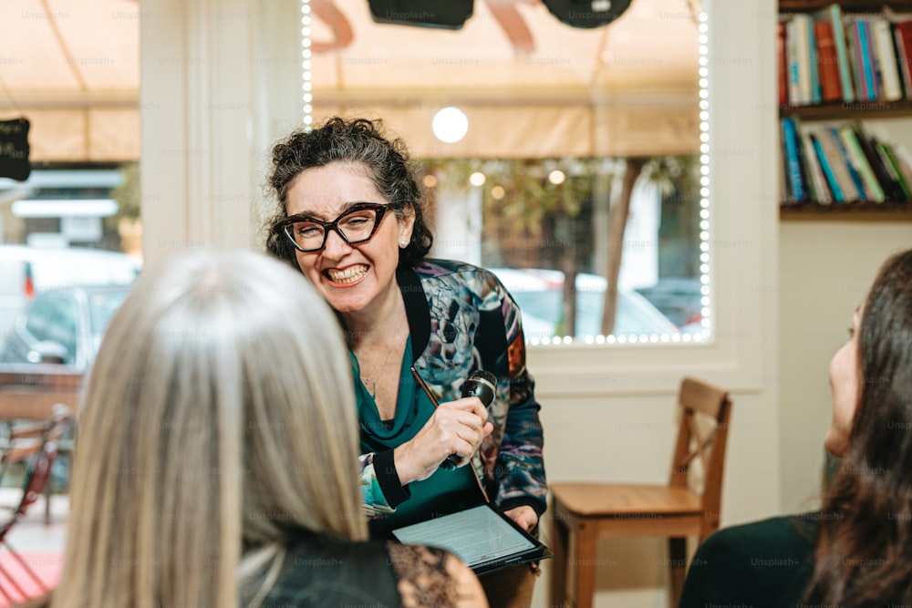 a woman with glasses talking to a group of people