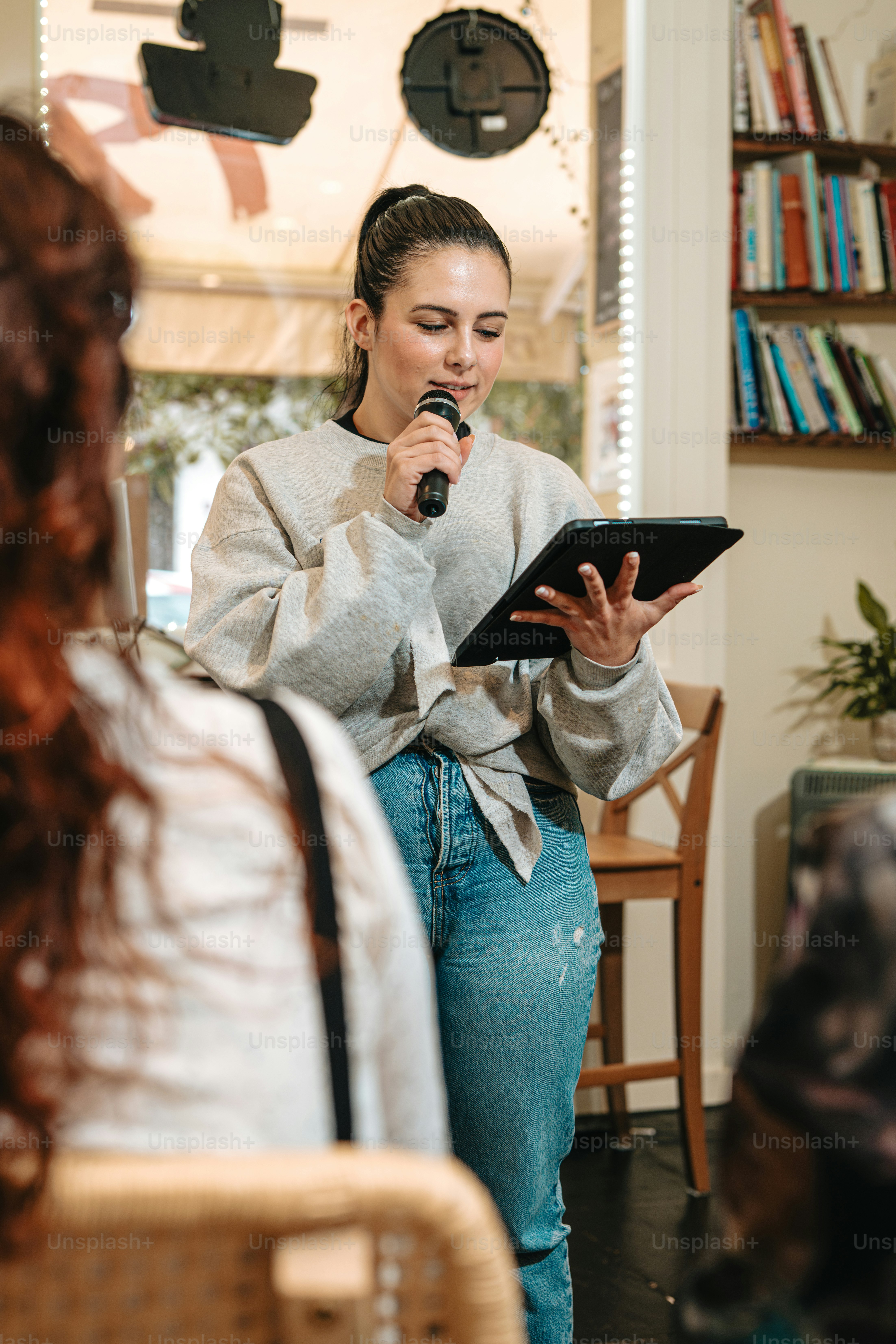 a woman standing in front of a mirror holding a tablet
