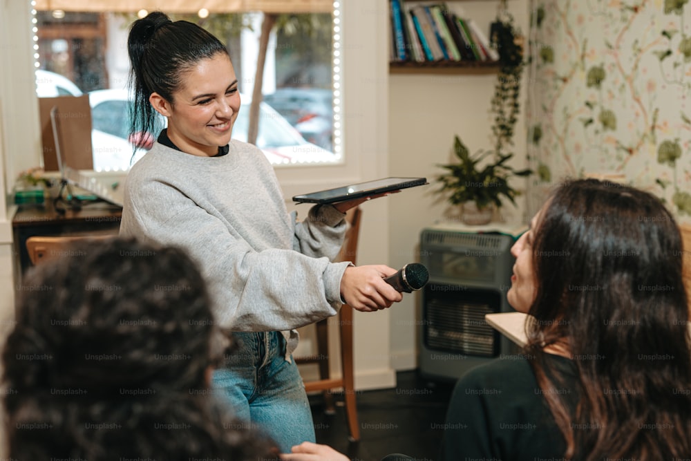 a woman holding a hairdryer in front of a group of women