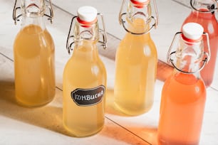 a group of bottles of liquid sitting on top of a wooden floor