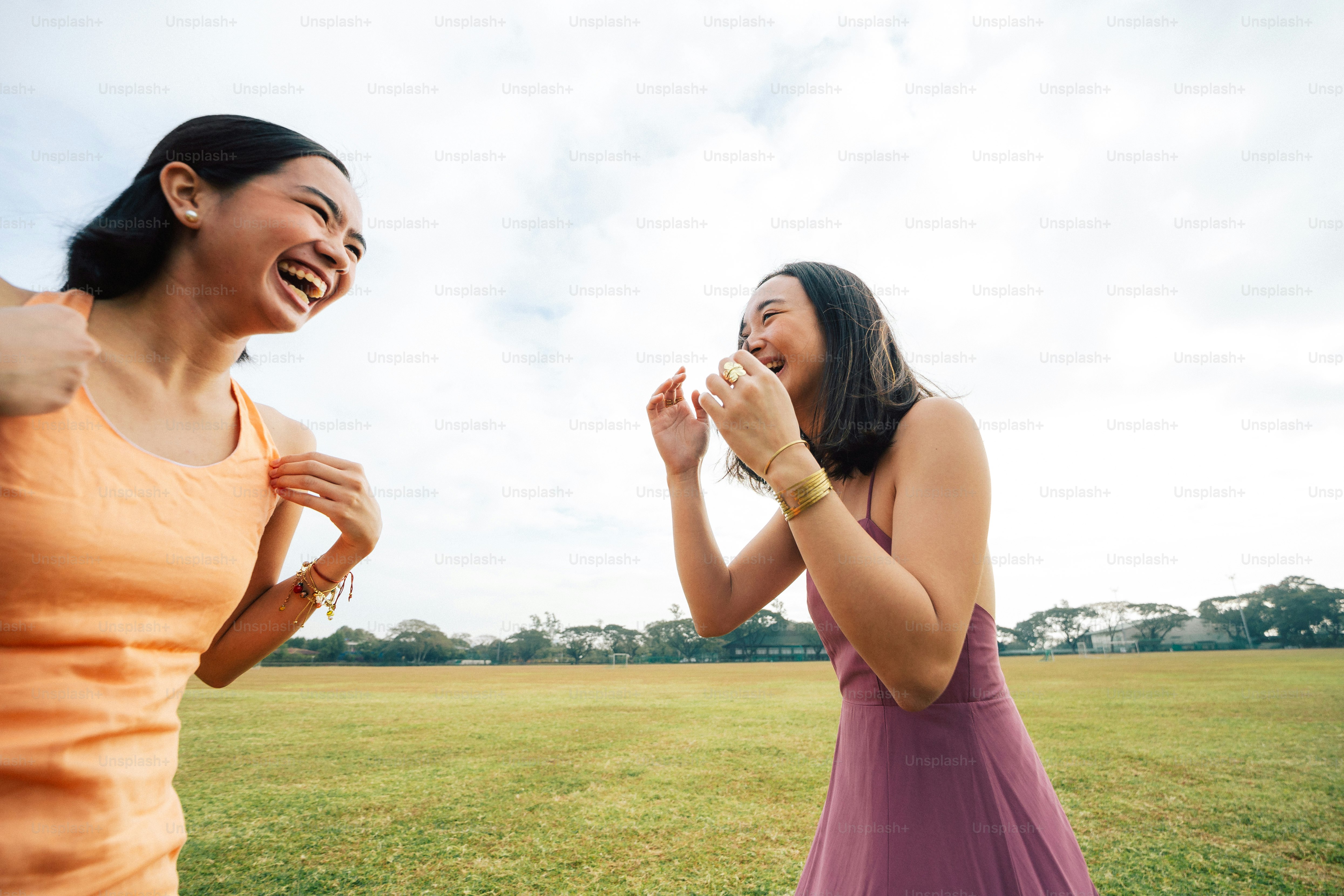 a couple of women standing on top of a lush green field