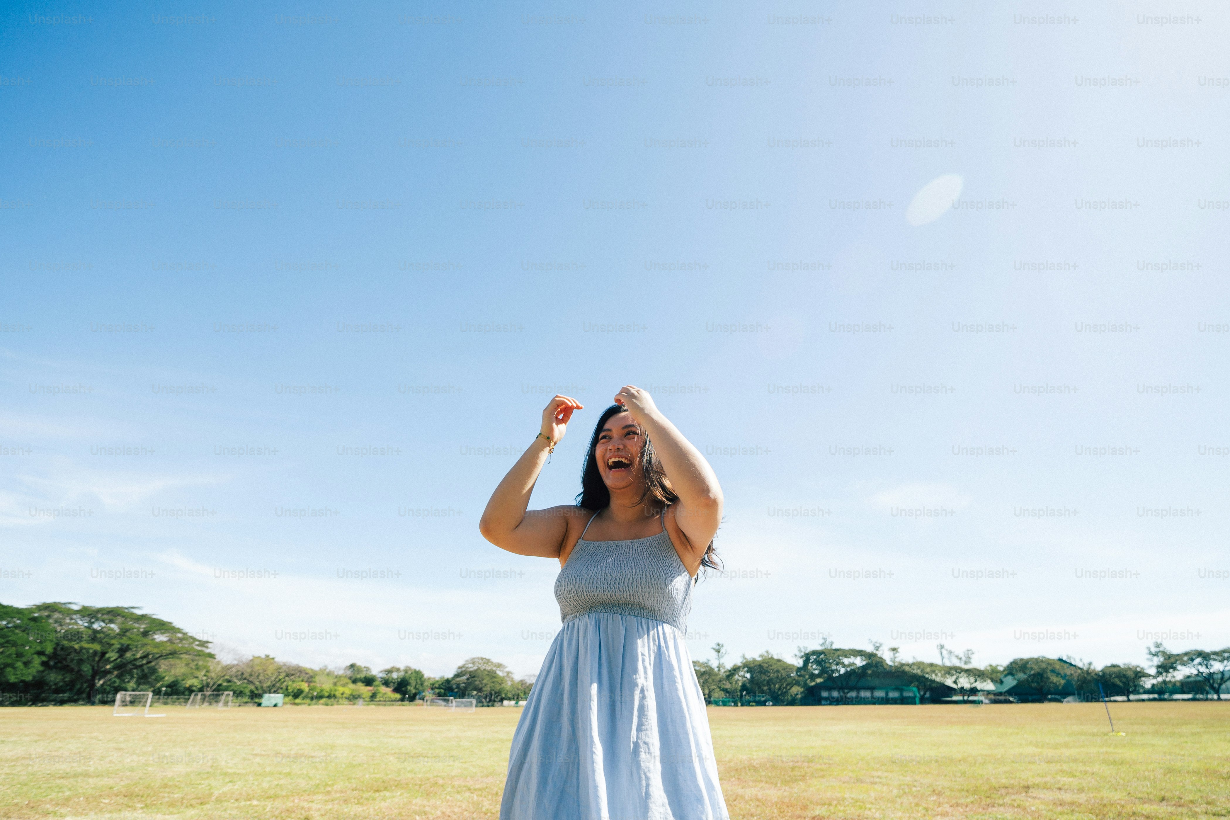 a woman in a blue dress standing in a field